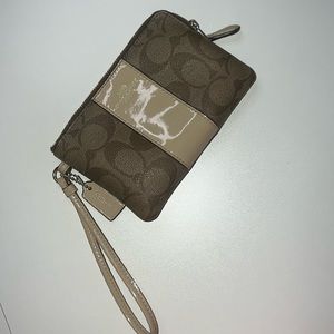 Beige Coach wristlet with gold embellishments